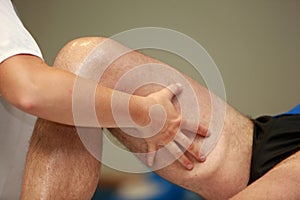 Hands massaging athlete's thigh after running