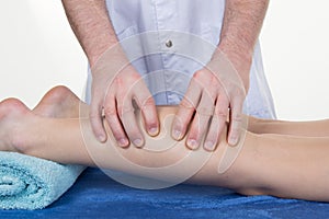 Hands massaging human calf muscle.Therapist applying pressure on female leg.