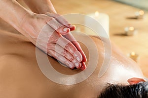Hands massaging spinal column on woman.