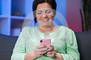 Hands Of Mature Woman Using Phone. Smartphone in the hands of an elderly person. Female in her 50s texting messages in