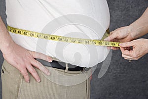 Hands Measuring Abdomen Of Obese Man photo