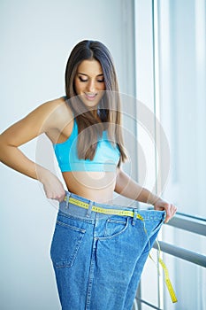 Hands measuring waist with a tape. Slim and healthy woman