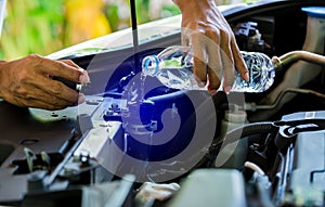 Hands of Mechanic Check water in Car radiator and Add water to car radiator