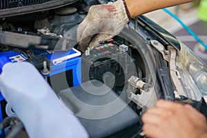 The hands of the mechanic replacing the fuse in the car. The mechanic selects the correct fuse. selective focus