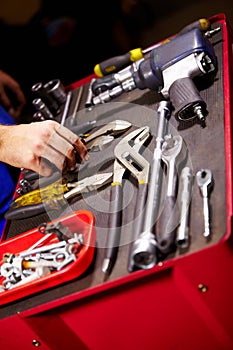 Hands, mechanic and toolbox for auto service at workshop, small business or garage. Closeup, man and equipment, toolkit