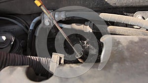 Hands of a mechanic who is checking and preparing to change oil and fill the engine oil of a diesel engine