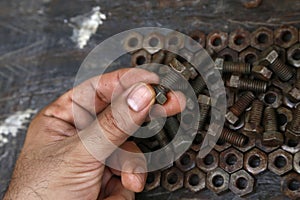 Hands of a mechanic or worker. Man working with rusty nuts and bolts. Manual work table. Oil dirty hands. Employee. Worker.