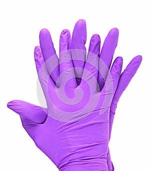 Hands of a medic wearing violet latex gloves, white background