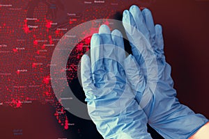 Hands in medical gloves in front of coronavirus spread USA map