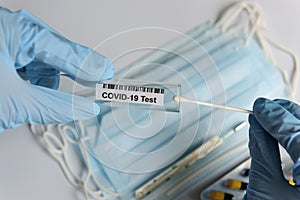 Hands in medical gloves holding COVID-19 swab. Test tube for taking patient sample, PCR DNA testing protocol process. Nasal swab