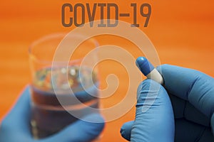 Hands medical gloves take pill - doctors sick, coronavirus, lettering covid19