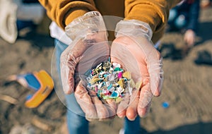 Hands with microplastics on the beach