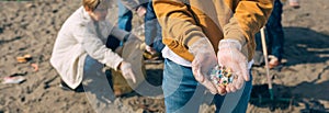 Hands with microplastics on the beach