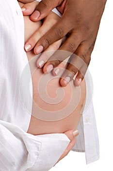 Hands of a mixed race couple on pregnant belly