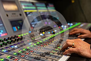 Hands mixing on a broadcast audio console