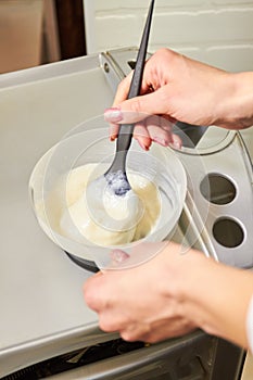 Hands mixing hair dye, bowl.