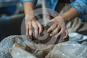 Hands molding clay in a clay workshop to teach people how to mold the material to create figures