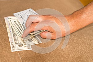 Hands with money hide them under mattress. A man`s hand takes money from under the pillow. A man hides money in a bed