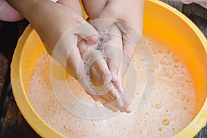 Hands of mother assisting child while washing hands