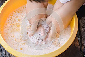 Hands of mother assisting child while washing hands with soap to prevent virus and bacteria for corona virus covid19 protection