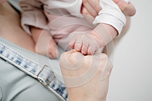 Hands of mother and child close-up on a white background.