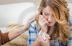 Hands of mother consoling sad teen daughter crying