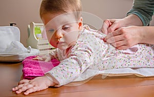 Hands of mother wearing her baby lying down