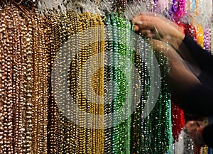 hands move as she chooses necklaces in a jewelry store