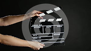 Hands with movie production clapper board, on