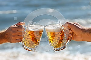 Hands with mug of beer making toast