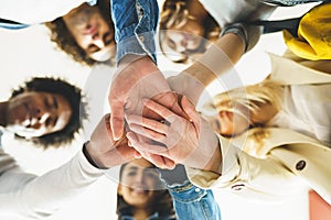 Hands of a multi-ethnic group of friends joined together as a sign of support and teamwork.