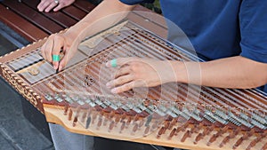 hands of musician playing on cimbalom or dulcimer,