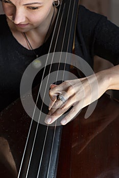Hands of a musician playing on a contrabass closeup