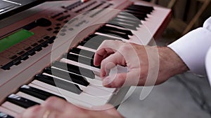 Hands of a musician playing an electronic piano, a synthesizer. Mixes the sound. Jazz, rock, pop music.