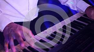Hands of musician playing keyboard in concert