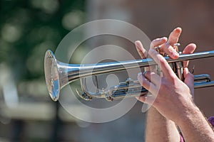 Hands of the musician playing a trumpet. close up musician with trombone on a public event