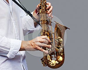 Hands of a musician with the saxophone