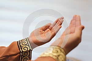 Hands of muslim people praying with mosque interior background.