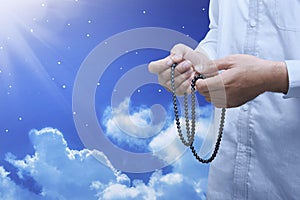 Hands of muslim person with prayer beads in hand praying