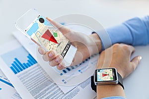 Hands with navigator map on smart phone and watch