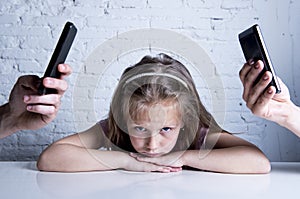 Hands of network addict parents using mobile phone neglecting little sad ignored daughter bored photo