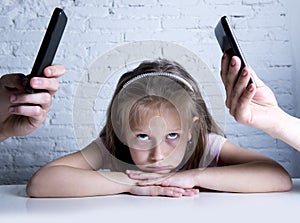 Hands of network addict parents using mobile phone neglecting little sad ignored daughter bored
