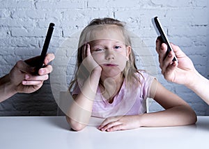 Hands of network addict parents using mobile phone neglecting little sad ignored daughter bored photo