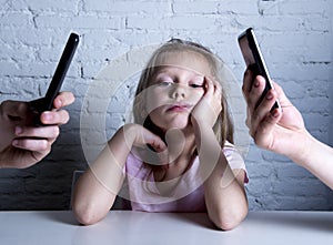 Hands of network addict parents using mobile phone neglecting little sad ignored daughter bored photo