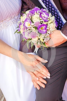 Hands of newlyweds with wedding rings