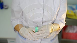 Hands of nurse holding syringe and sprinkle up the liquid medicine. Spraying drug from syringe. Squeezing liquid out of