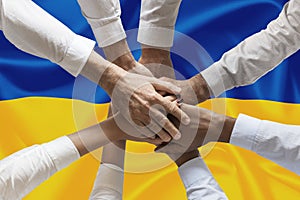 Hands o people united on ukrainian flag hands together over the national flag of Ukraine, in demonstration of union against the wa