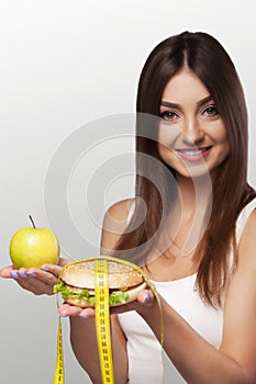 Hands offer an apple healthy food and cakes unhealthy food t