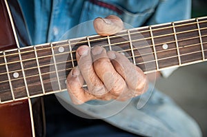 Hands of the old man hold guitar