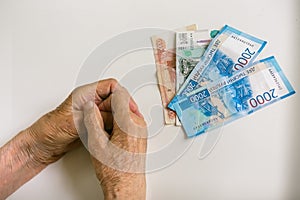 Hands of an old man with large denominations. Russia.